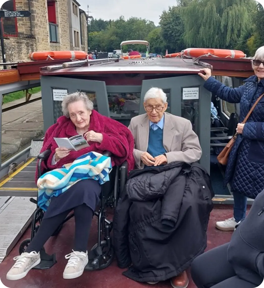 Carer supporting an older adult in a wheelchair