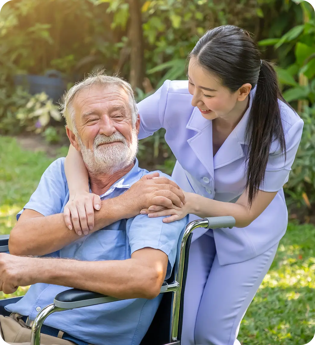 Carer supporting an older adult in a wheelchair